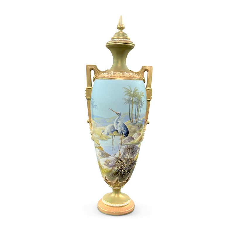 Royal Worcester small lidded urn featuring hand painted storks in a mountain scene with gilding and gold arms.