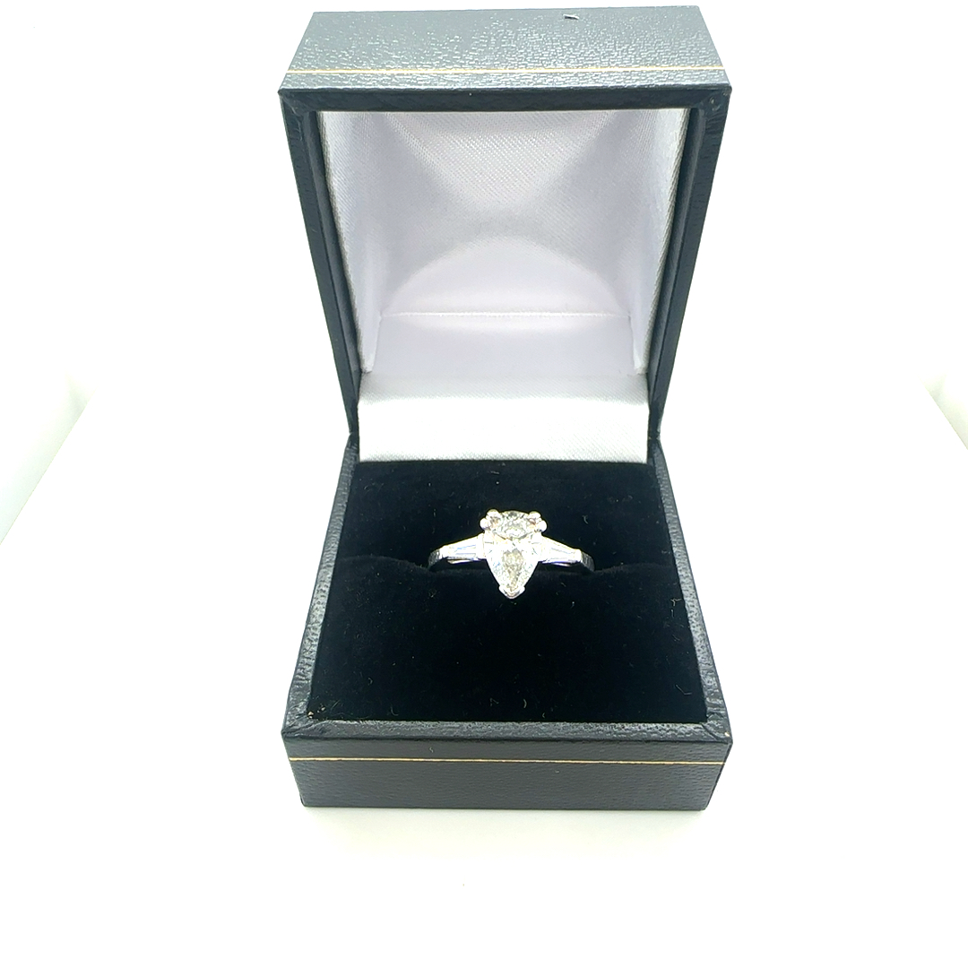 Platinum Pear shaped diamond solitaire ring with diamond baguettes