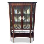 Superb English Sheraton style 2 door mahogany display cabinet with fine satinwood crossbanding and marquetry with bowed front corners by Waring & Gillow c.1890