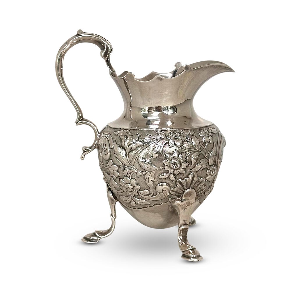 George IV sterling silver embossed tri leg jug London c.1825