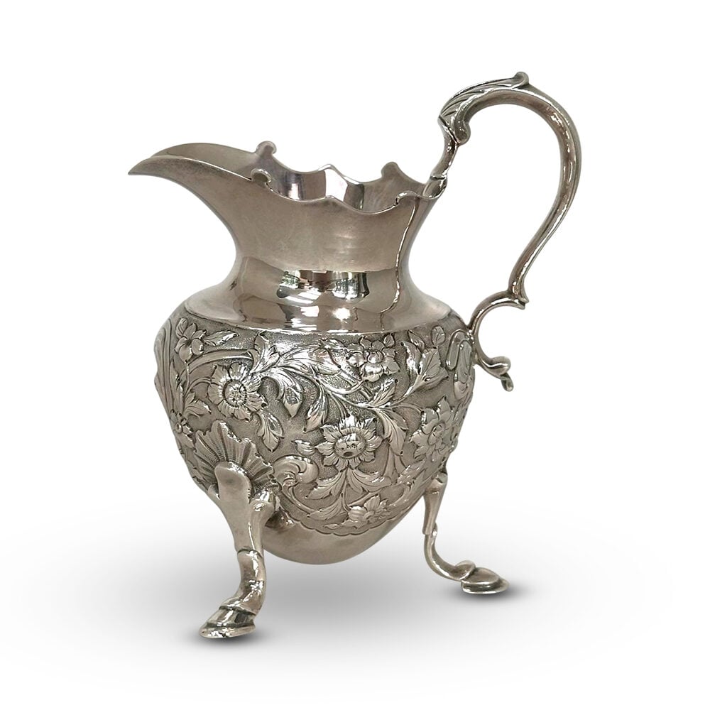 George IV sterling silver embossed tri leg jug London c.1825